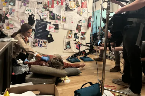 The crew filming a staged crime scene on a detective’s office set
